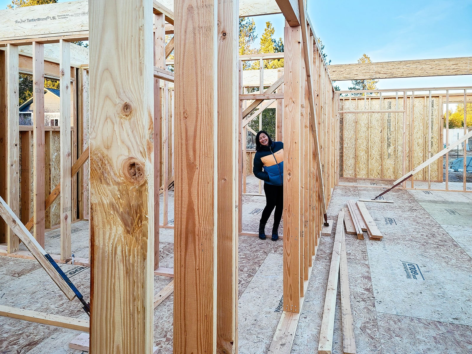 Smiling woman standing inside a house still in framing stage